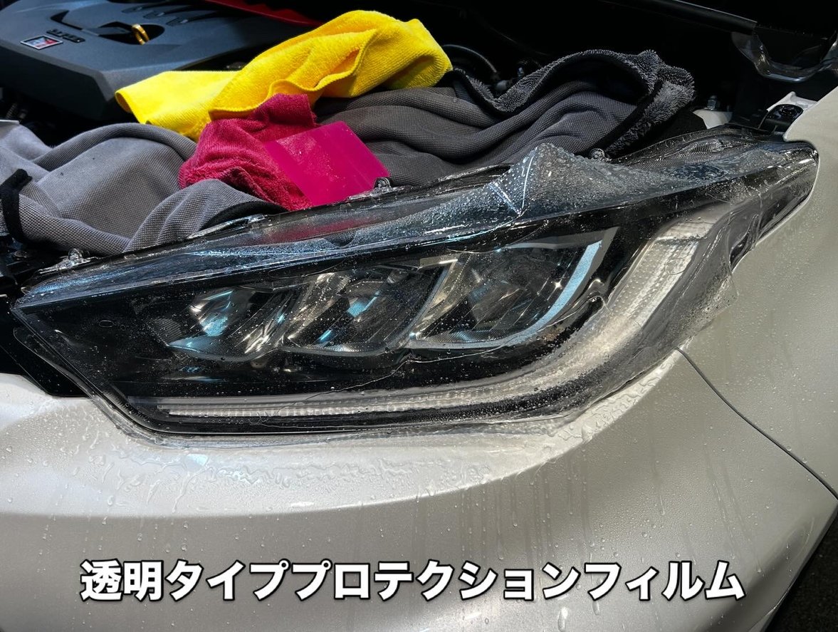 透明タイプのヘッドライトプロテクションフィルム施工中