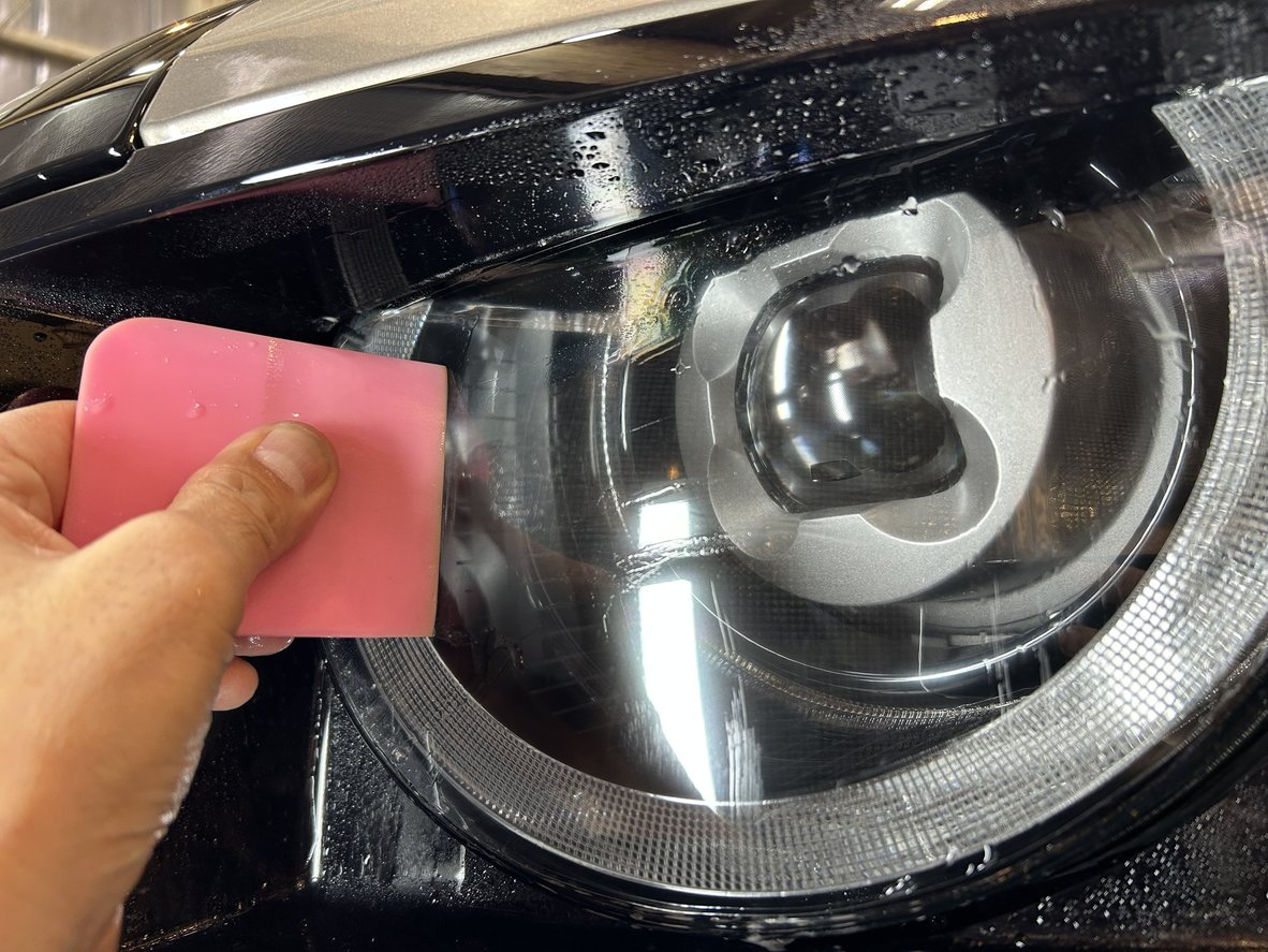 スキージーで施工液を抜きながら圧着している様子